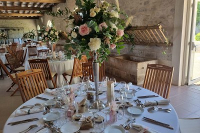 Chaises blanches disposées en rangées sur une pelouse, face à une petite scène décorée pour un événement en plein air.