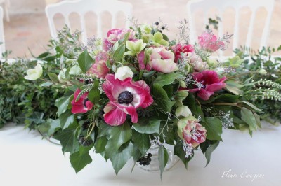 Chaises blanches disposées en rangées sur une pelouse, face à une petite scène décorée pour un événement en plein air.
