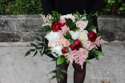 Chaises blanches disposées en rangées sur une pelouse, face à une petite scène décorée pour un événement en plein air.