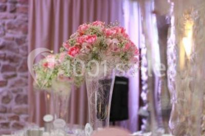 Terrasse en bois avec des chaises noires, adossée à une maison en bardage bois, sous un ciel nuageux.