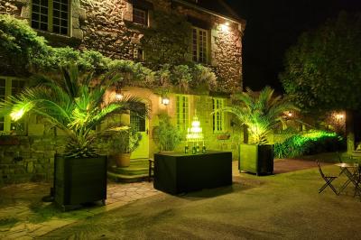 Terrasse en bois avec des chaises noires, adossée à une maison en bardage bois, sous un ciel nuageux.