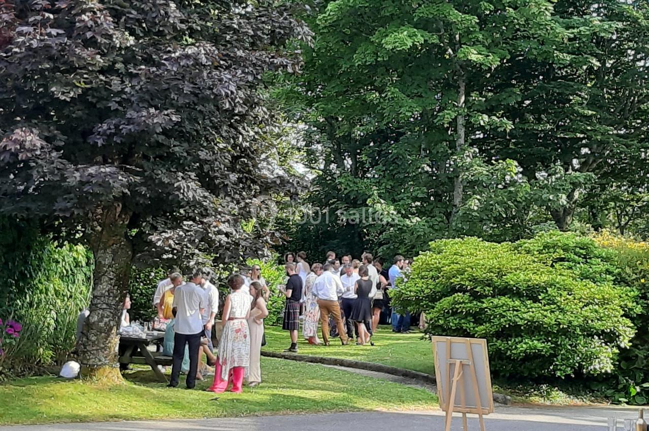 Un groupe de personnes discutant dans un jardin verdoyant par une journée ensoleillée.