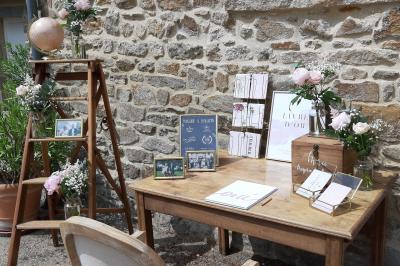 Terrasse en bois avec des chaises noires, adossée à une maison en bardage bois, sous un ciel nuageux.