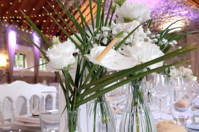 Terrasse en bois avec des chaises noires, adossée à une maison en bardage bois, sous un ciel nuageux.