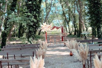 Groupe de personnes réunies en soirée en plein air, avec tables décorées et guirlandes lumineuses suspendues.