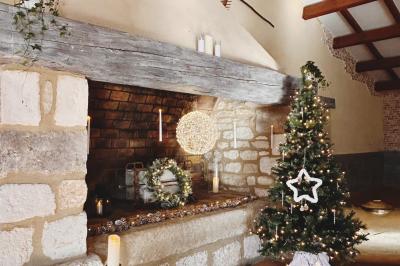 Groupe de personnes réunies en soirée en plein air, avec tables décorées et guirlandes lumineuses suspendues.