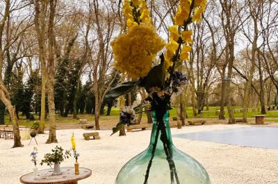 Groupe de personnes réunies en soirée en plein air, avec tables décorées et guirlandes lumineuses suspendues.
