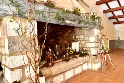 Groupe de personnes réunies en soirée en plein air, avec tables décorées et guirlandes lumineuses suspendues.