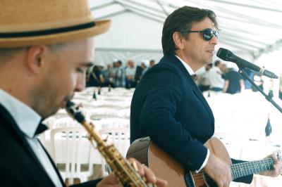 Un groupe de musiciens et une chanteuse se produisent sur scène sous des lumières colorées.