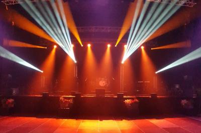 Un groupe de musiciens et une chanteuse se produisent sur scène sous des lumières colorées.