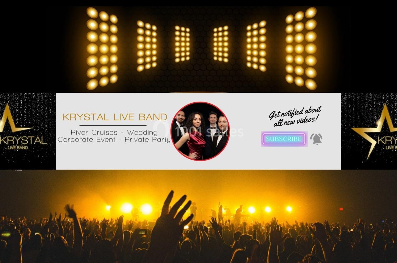 Des projecteurs illuminent une scène devant une foule avec une bannière promotionnelle pour un groupe musical.