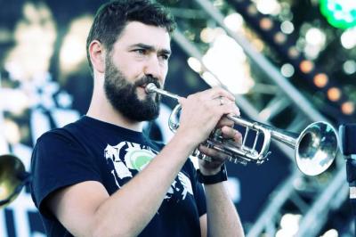 Un groupe de musiciens et une chanteuse se produisent sur scène sous des lumières colorées.