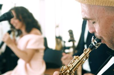 Un groupe de musiciens et une chanteuse se produisent sur scène sous des lumières colorées.