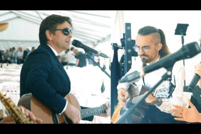 Un groupe de musiciens et une chanteuse se produisent sur scène sous des lumières colorées.