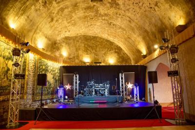 Un groupe de musiciens et une chanteuse se produisent sur scène sous des lumières colorées.