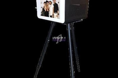 Borne photo sur trépied avec écran affichant une photo de groupe, utilisée pour des événements ou animations.