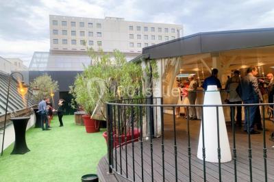 Buffet élégant avec plats variés disposés sur des tables noires, décoré de fleurs blanches dans une salle lumineuse.