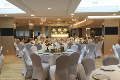 Buffet élégant avec plats variés disposés sur des tables noires, décoré de fleurs blanches dans une salle lumineuse.