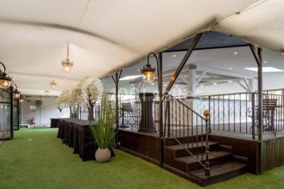 Buffet élégant avec plats variés disposés sur des tables noires, décoré de fleurs blanches dans une salle lumineuse.