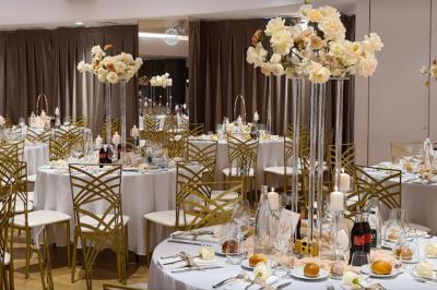 Buffet élégant avec plats variés disposés sur des tables noires, décoré de fleurs blanches dans une salle lumineuse.