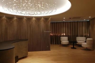 Buffet élégant avec plats variés disposés sur des tables noires, décoré de fleurs blanches dans une salle lumineuse.