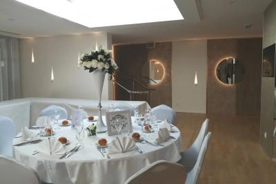 Buffet élégant avec plats variés disposés sur des tables noires, décoré de fleurs blanches dans une salle lumineuse.