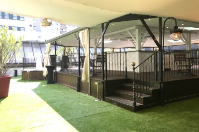 Buffet élégant avec plats variés disposés sur des tables noires, décoré de fleurs blanches dans une salle lumineuse.