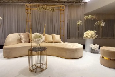 Buffet élégant avec plats variés disposés sur des tables noires, décoré de fleurs blanches dans une salle lumineuse.