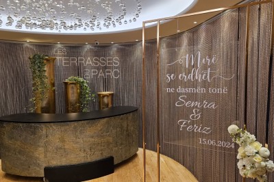 Buffet élégant avec plats variés disposés sur des tables noires, décoré de fleurs blanches dans une salle lumineuse.