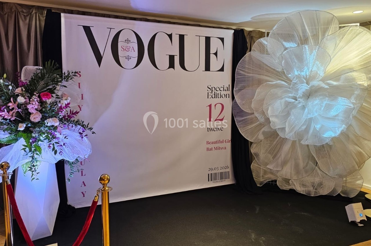 Panneau décoratif de style magazine avec fleurs et grand nœud blanc, entouré de cordons rouges.