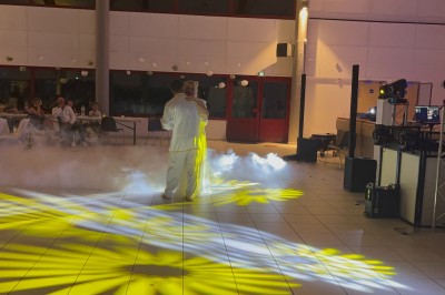 Un groupe de cinq personnes pose sous une tente éclairée, avec des équipements audio visibles en arrière-plan.