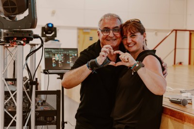 Un groupe de cinq personnes pose sous une tente éclairée, avec des équipements audio visibles en arrière-plan.