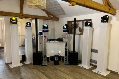 Un groupe de cinq personnes pose sous une tente éclairée, avec des équipements audio visibles en arrière-plan.