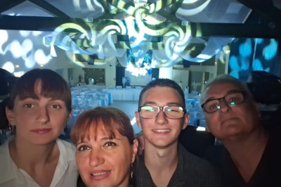 Un groupe de cinq personnes pose sous une tente éclairée, avec des équipements audio visibles en arrière-plan.