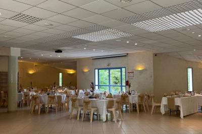 Cuisine professionnelle avec plan de travail en inox, cuisinières, hotte d'extraction et murs carrelés blancs.