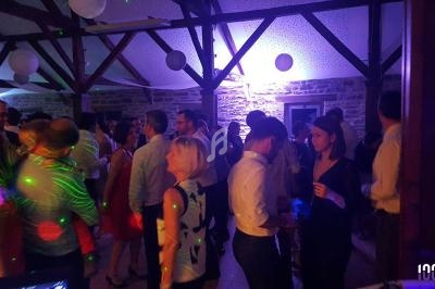 Groupe de personnes dans une salle éclairée par des lumières colorées lors d'une soirée dansante.