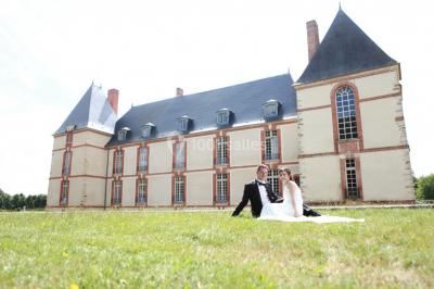 Château éclairé sous un ciel nocturne avec une pleine lune visible en arrière-plan.