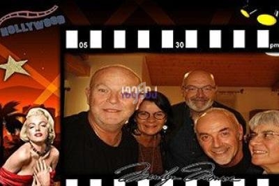 Des personnes souriantes posent ensemble dans un cadre décoré sur le thème du cinéma, avec des éléments hollywoodiens.