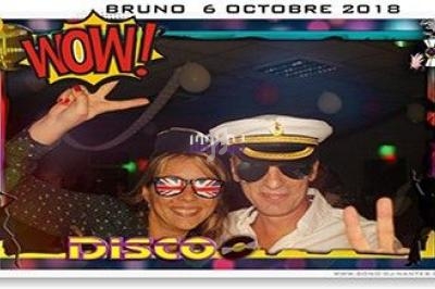 Deux personnes déguisées en tenue festive, lunettes fantaisie et casquette de marin, posent dans un cadre à thème disco.