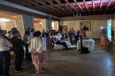 Un groupe de personnes debout dans une salle, regardant une projection sur un écran.