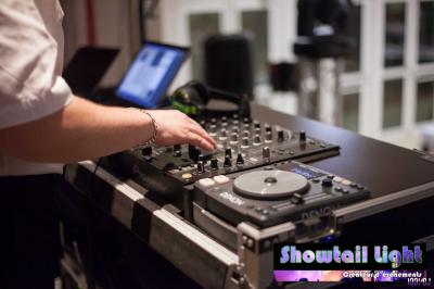 Des personnes dansent dans une salle sombre éclairée par des faisceaux lumineux colorés et des effets laser.