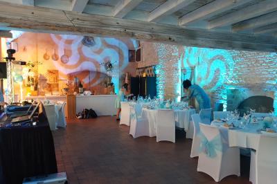 Des personnes dansent dans une salle sombre éclairée par des faisceaux lumineux colorés et des effets laser.