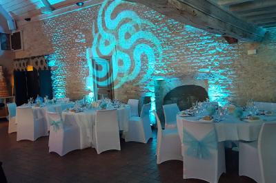 Des personnes dansent dans une salle sombre éclairée par des faisceaux lumineux colorés et des effets laser.