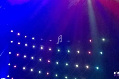 Jeu de lumières colorées sur une scène sombre avec des projecteurs rouges, bleus et blancs.