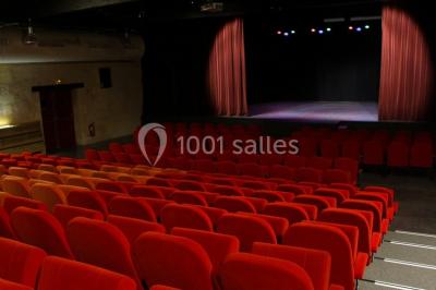 Bâtiment en bois avec une clôture métallique et un panneau indiquant ’La Forge’, entouré de végétation.