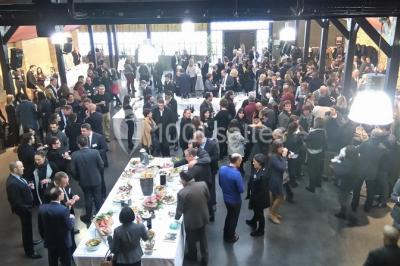 Bâtiment en bois avec une clôture métallique et un panneau indiquant ’La Forge’, entouré de végétation.