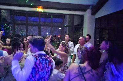 Table décorée avec des bougies allumées en premier plan, devant une fontaine éclairée et une réception en soirée.