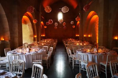 Table décorée avec des bougies allumées en premier plan, devant une fontaine éclairée et une réception en soirée.