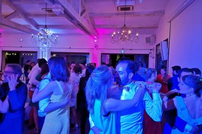 Quatre musiciens en costume jouent de la guitare et du cajón en extérieur lors d'un événement.