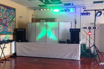 Installation de matériel de sonorisation et éclairage dans une salle avec un clavier électronique sur le côté.